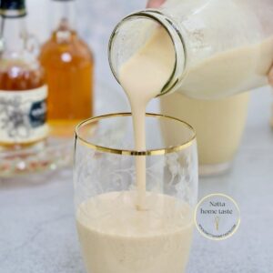 ponche de huevo en vaso de vidrio con borde dorado