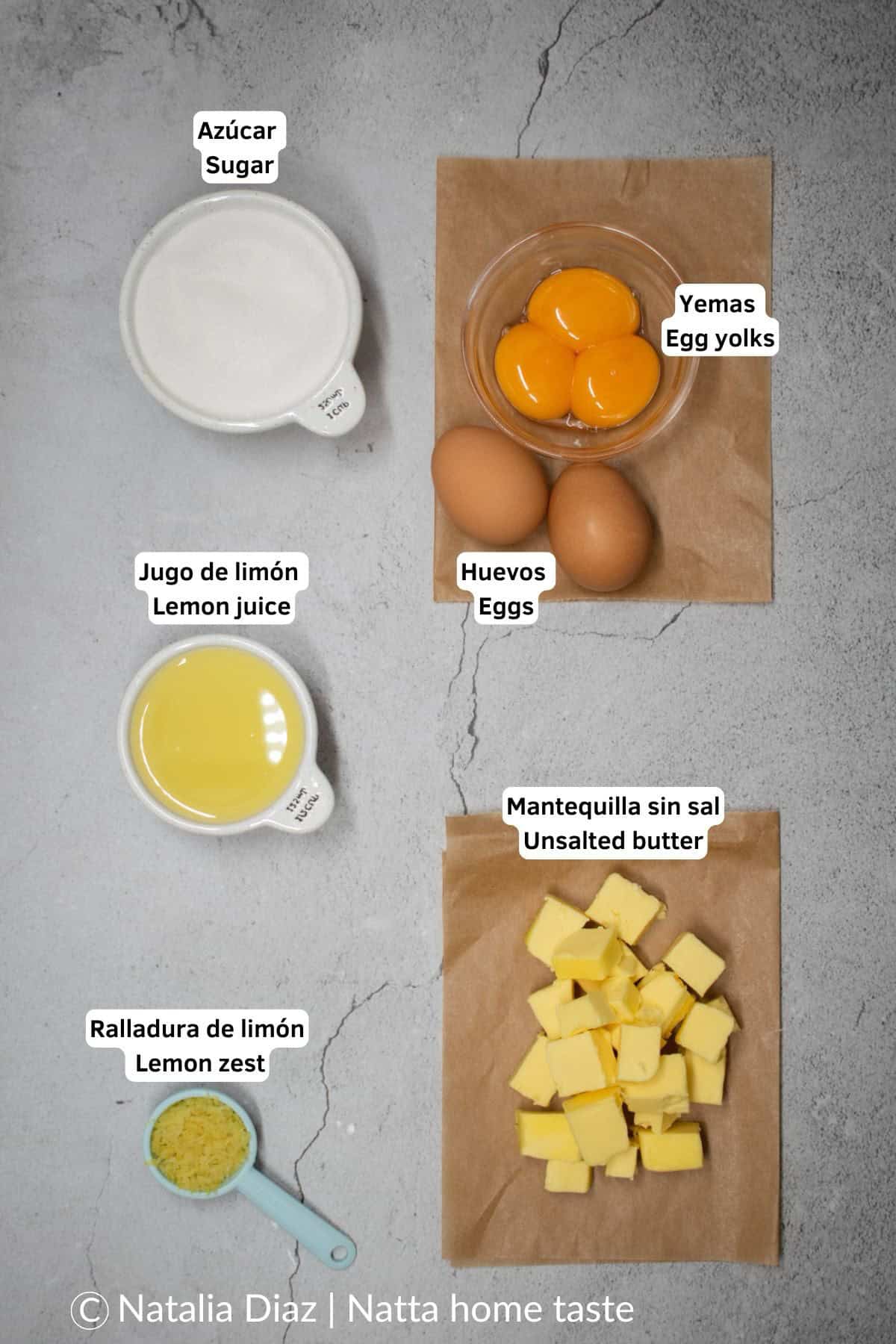 ingredientes para preparar un lemon curd casero. Mantequilla en cubos, huevos, yemas de huevo, azúcar, jugo de limón y ralladura de limón.