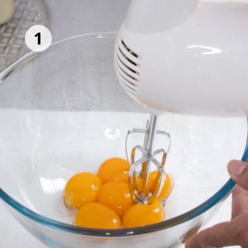 tazón grande de vidrio con yemas y batidora eléctrica