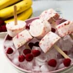 paletas de banana y frutilla sobre un plato con hielo