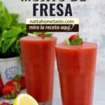 dos vasos de vidrio con mojito de fresa y fresas y limón frescos al lado