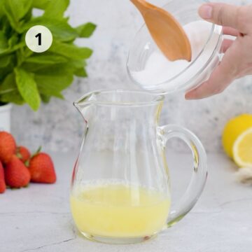 Jarra d vidrio con zumo de limón y azúcar