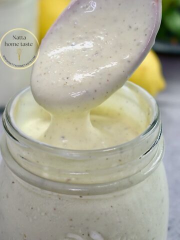 vinagreta de yogur en un contenedor de vidrio con una cuchara