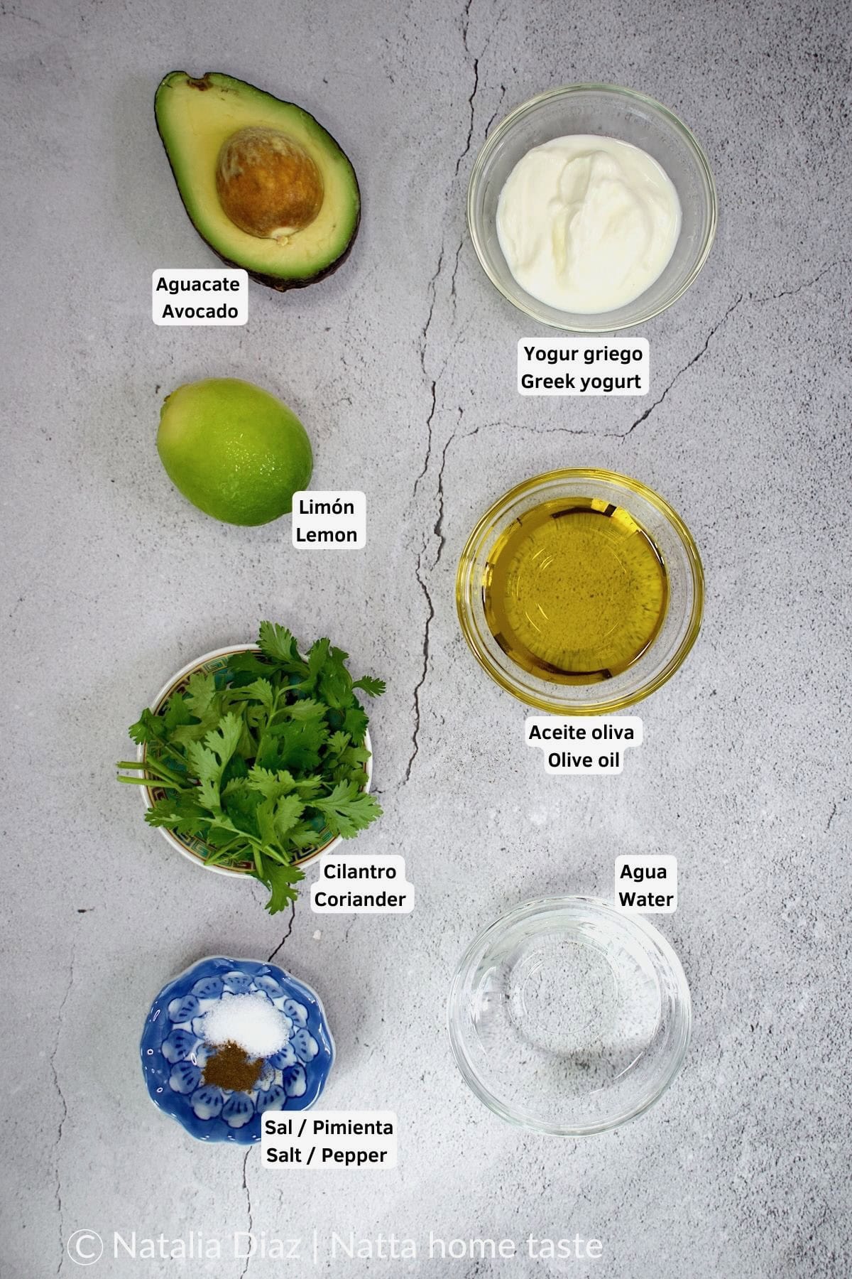 imagen desde arriba de ingredientes para preparar un aderezo de aguacate y cilantro sobre una mesa. Aguacate, limón, yogur griego, aceite de oliva, agua, sal y pimienta y hojas de cilantro.