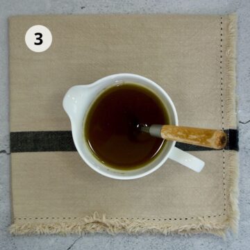 vinagreta o aderezo en una taza blanca con una cuchara 