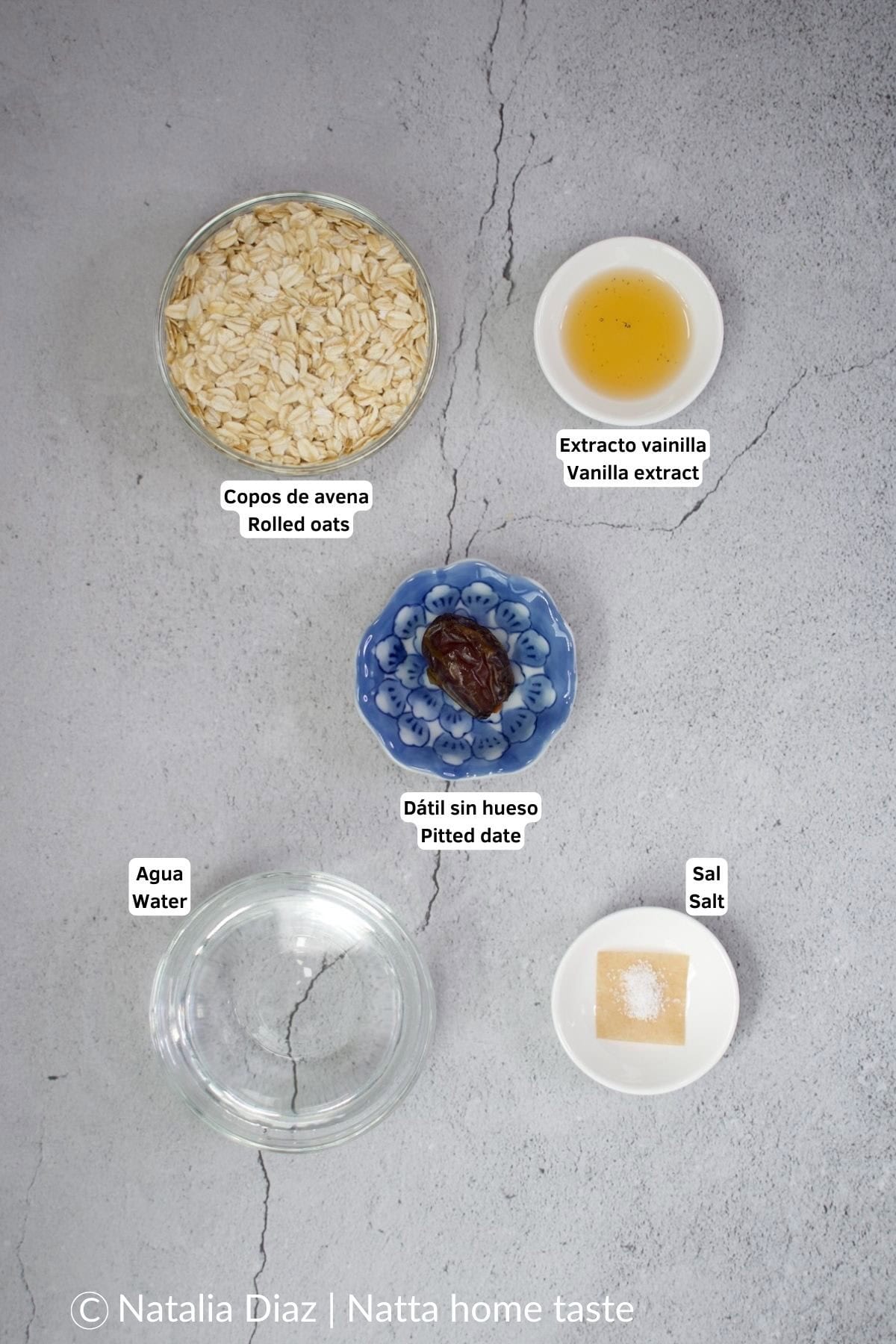 imagen desde arriba de los ingredientes para preparar leche de avena casera. Copos de avena, agua, extracto de vainilla, sal, dátil.