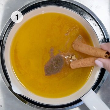 Preparación inicial del té de cúrcuma en una olla, con cúrcuma, jengibre y canela infusionando en agua caliente.