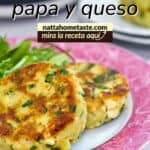 Primer plano de tortitas de papa con queso y espinacas, doradas y servidas en un plato decorado con hojas verdes.