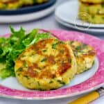 Tortitas de papa con queso mozzarella doradas al sartén, servidas con ensalada verde como acompañante.