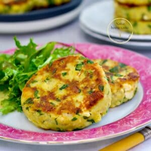Tortitas de papa con queso mozzarella doradas al sartén, servidas con ensalada verde como acompañante.