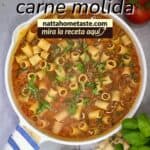 Pasta con carne molida en sartén: pasta corta en salsa de tomate con albahaca, vista superior en sartén blanco; cena rápida one-pot.