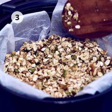 Paso 3: mezcla de granola (avena, nueces y semillas) extendida en la canasta de una freidora de aire forrada con papel para hornear, mientras una cuchara de madera la distribuye; círculo con número 3 indicando el paso.