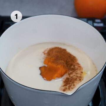 Mezcla de leche, puré de calabaza y especias en una olla para preparar Pumpkin Spice Latte casero, el primer paso de esta bebida otoñal cremosa.