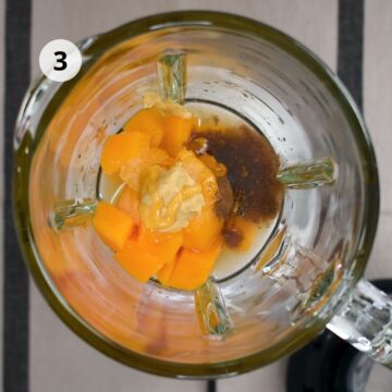Añadir mango, mostaza, miel, jugo de limón, agua, sal y pimienta al voso de una licuadora.
