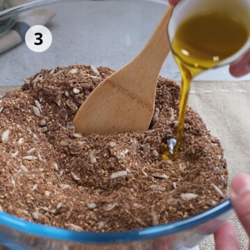 Agregando aceite de oliva a la mezcla de linaza molida y semillas para pan de linaza