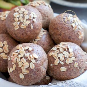 Rollitos de pan de avena sin huevo recién horneados y decorados con hojuelas de avena.