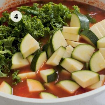 Trozos de calabacín y kale recién añadidos al caldo de tomate