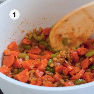 Zanahoria, apio, cebolla y ajo sofriéndose con especias para preparar sopa minestrone vegetariana.